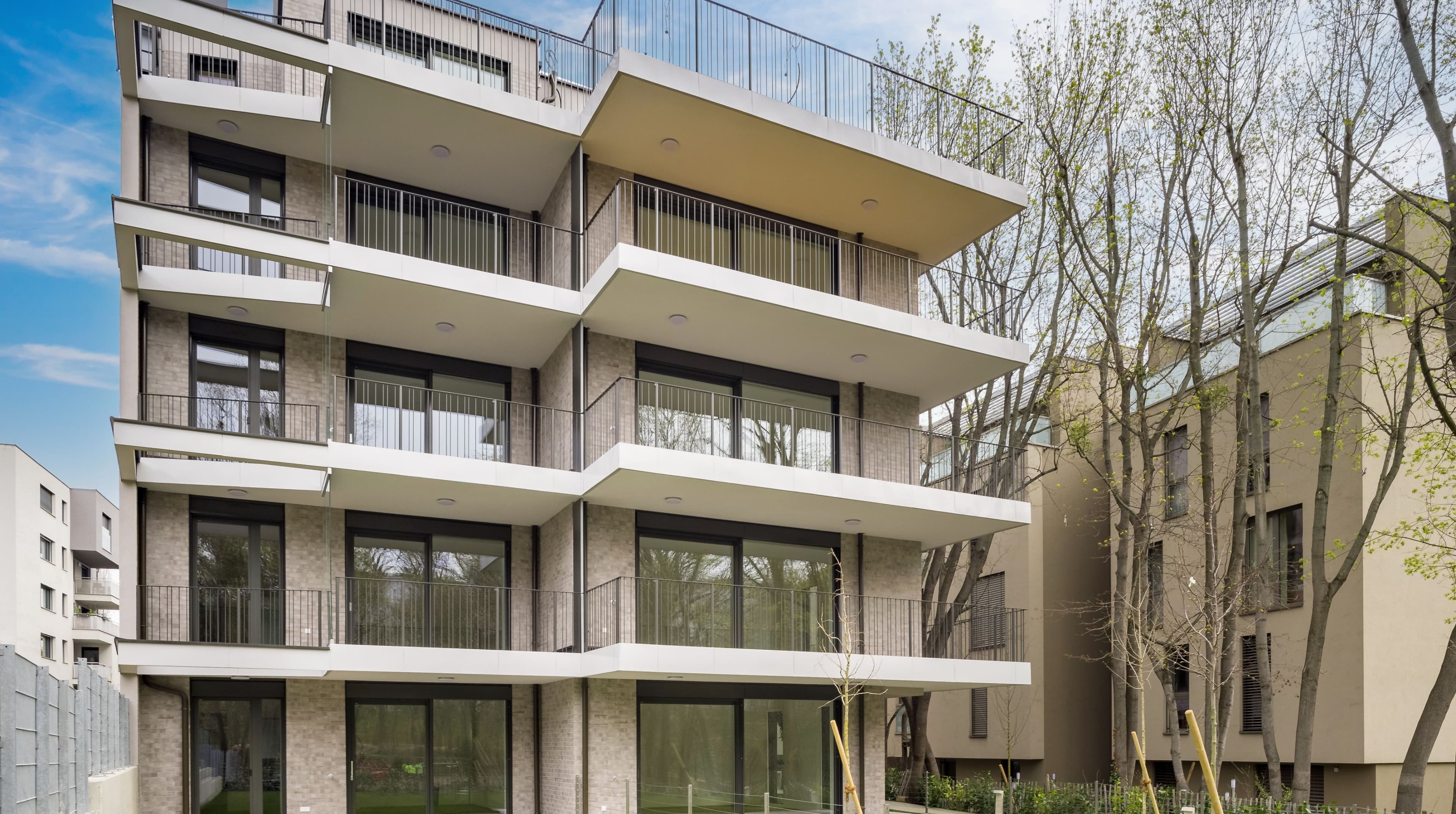 Außenansicht der Park Suites Wohnhäuser in der Hockegasse mit Balkonen und Bäumen