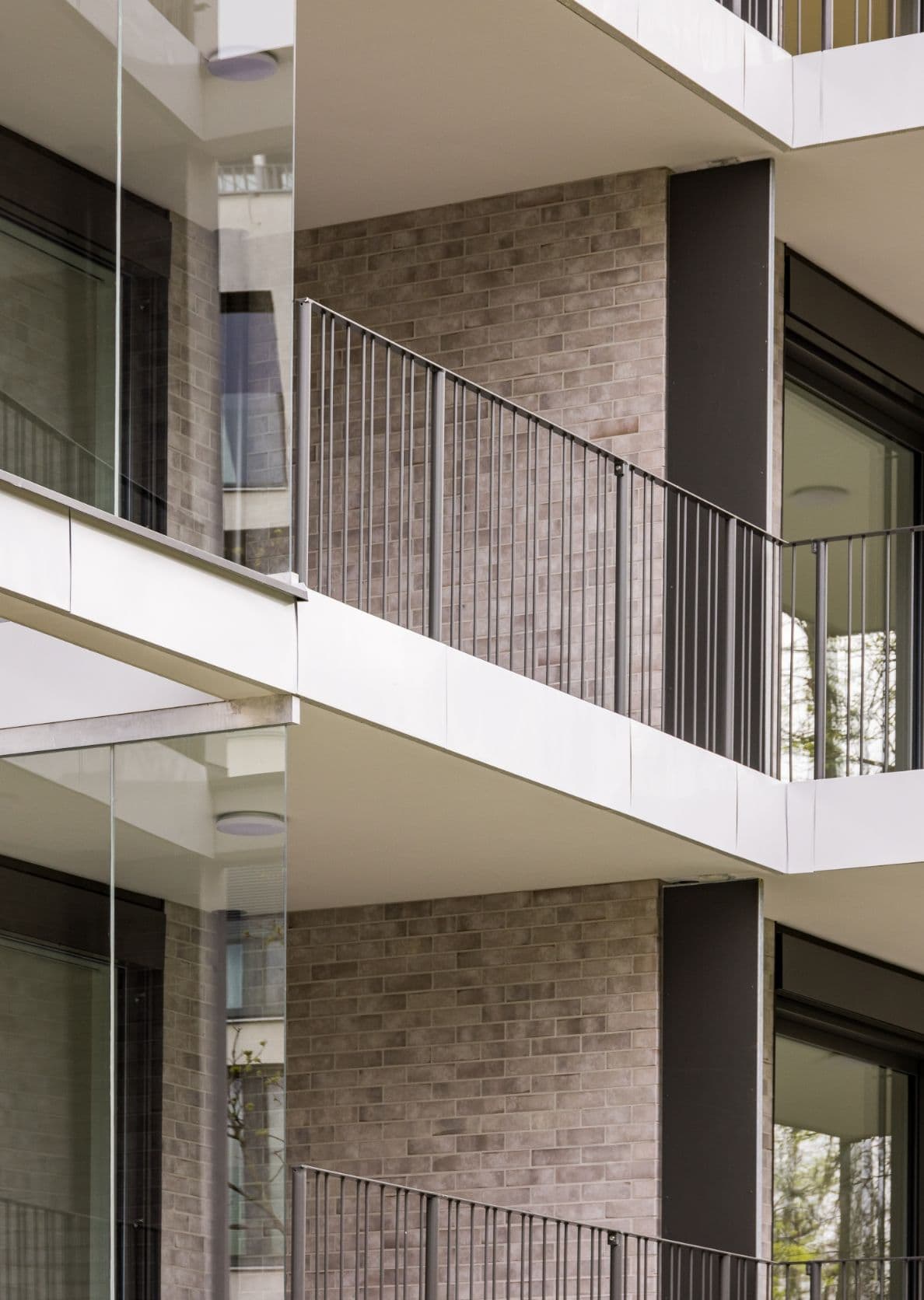 Moderne Ziegelsteinfassade der Park Suites Wohnhäuser mit Balkonen, umgeben von Grünpark
